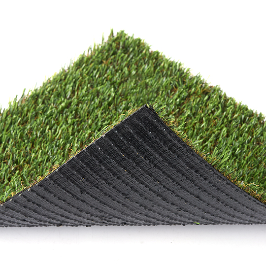 A cut corner of green artificial turf folded back to show its black backing