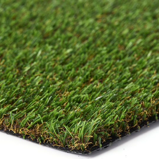Close-up of a turf sample corner with green and tan fibers and a dark backing edge