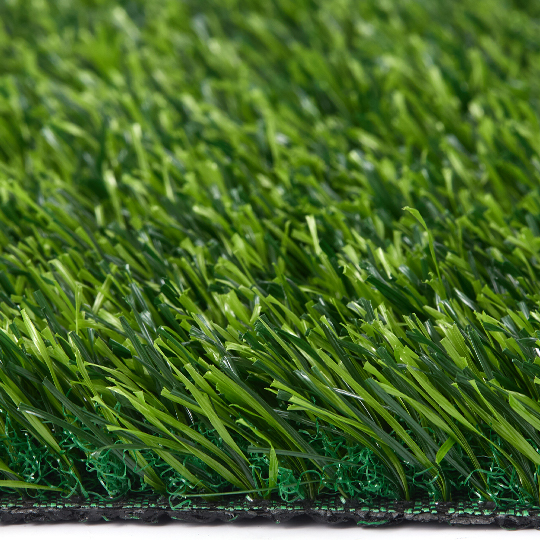 Low side close-up of green turf blades and the backing edge