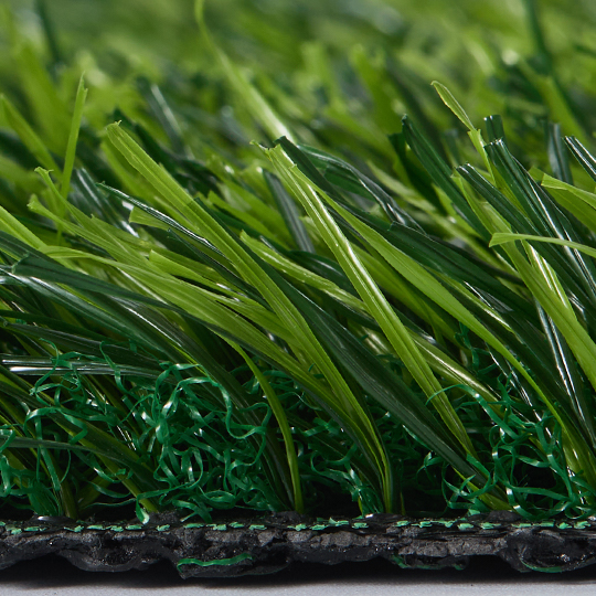 Turf sample corner folded back to show dark backing beneath the fibers
